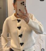 Cream knit cardigan with black bow buttons